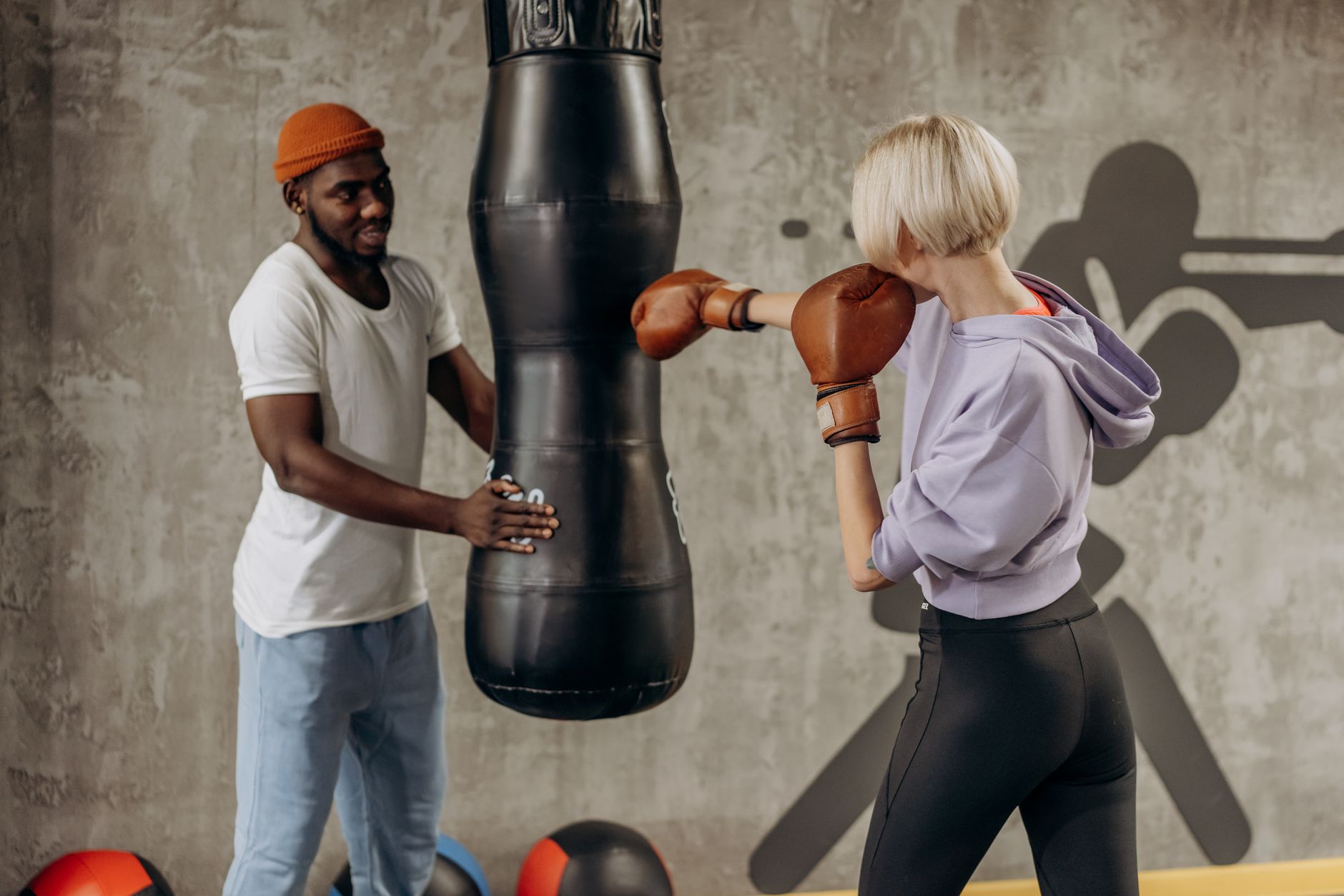 Voedingsschema op maat of calorie app: Man en vrouw trainen boksen in een sportschool met een bokszak
