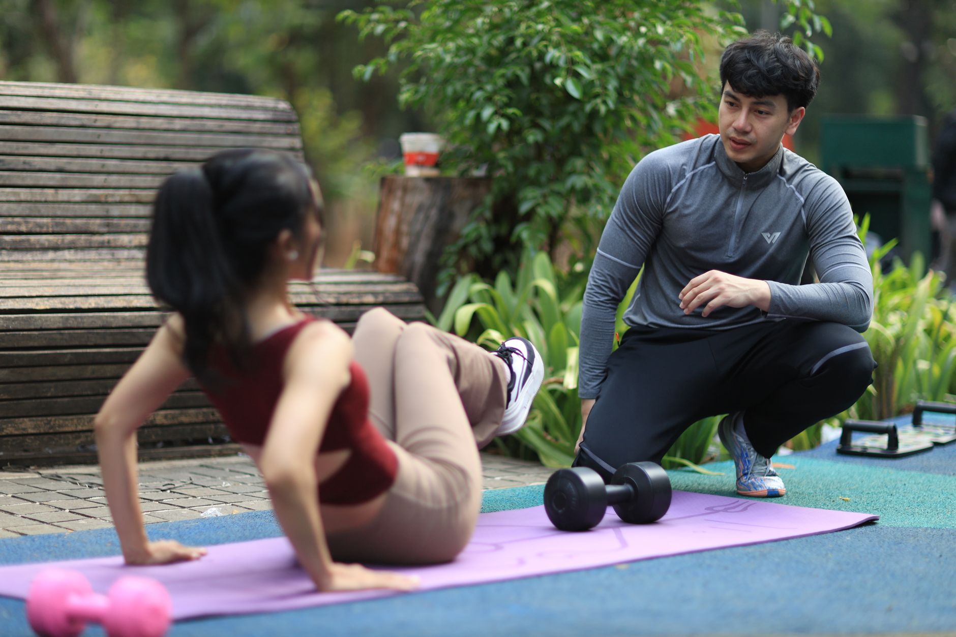 Trainer begeleidt oefeningen tijdens trainingsessie in park Jakarta